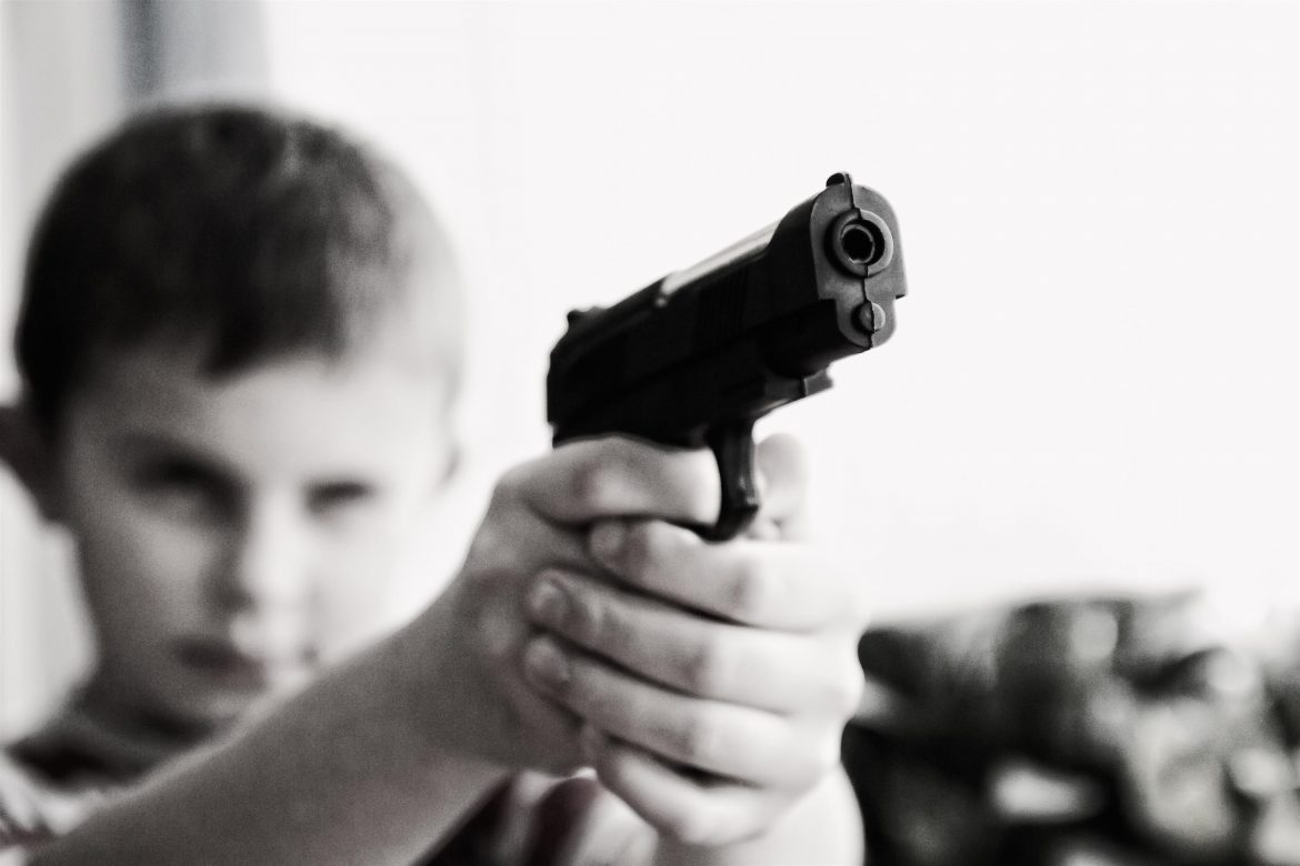 grayscale-photo-of-a-boy-aiming-toy-gun-selective-focus-52984