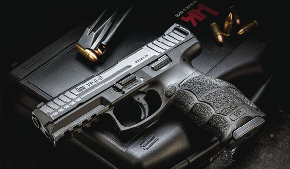 Pistola HK VP9-B cinza sobre maleta, com carregador e cartuchos 9mm ao lado