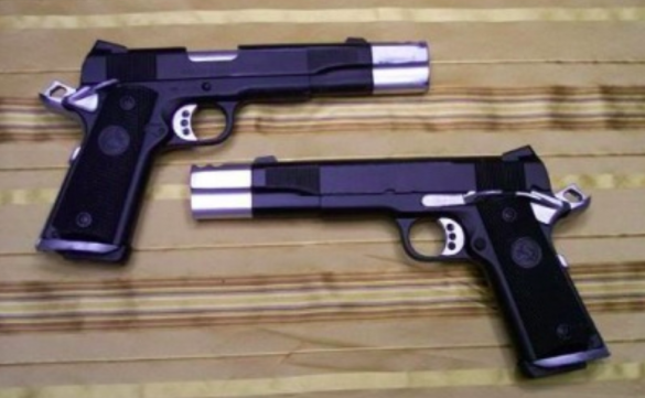 Duas pistolas da plataforma 1911 lado a lado sobre um tecido listrado